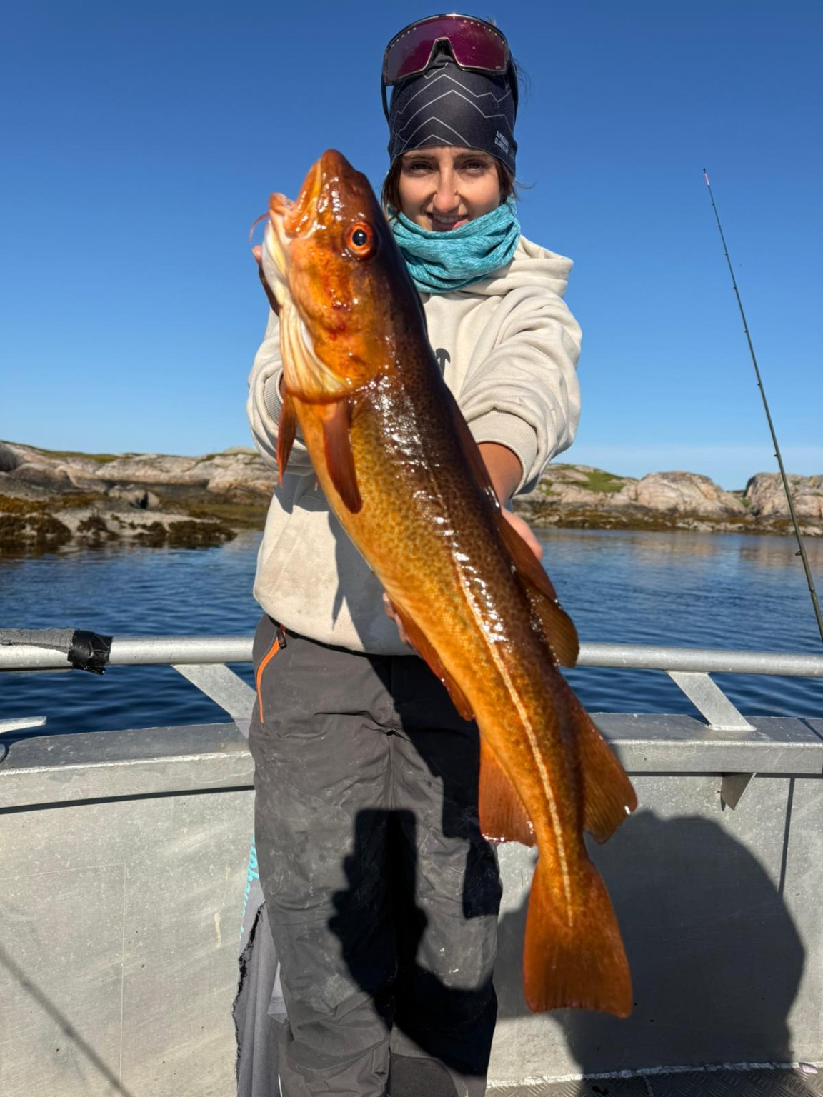 Fischerin mit einem grossen Dorsch auf einem Boot in Norwegen