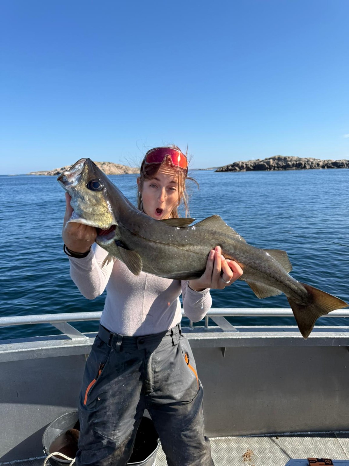 Fischerin mit einem grossen Fisch vor der norwegischen Küste